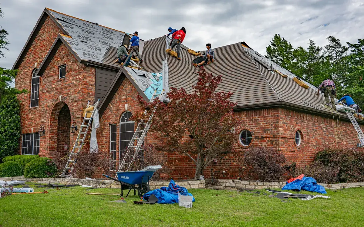 Crew installing a new roof on a brick house