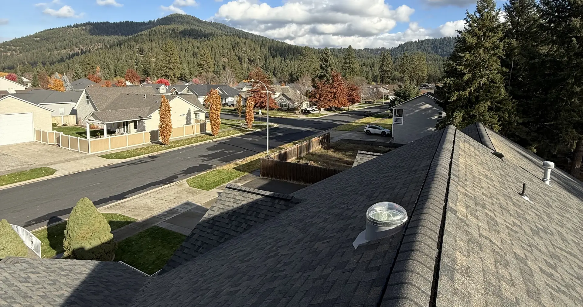 New Lakeview shingle roof overlooking a North Idaho neighborhood and forested hills in fall